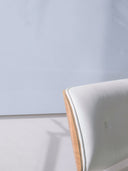 Wandpaneel in der Farbe Hellblau, installiert an der Wand vor einem Sessel