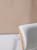 Wandpaneel in der Farbe Hellbraun, installiert an der Wand vor einem Sessel