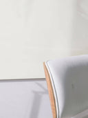 Wandpaneel in der Farbe Lichtbeige, installiert an der Wand vor einem Sessel