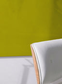 Wandpaneel in der Farbe Olivegrün, installiert an der Wand vor einem Sessel