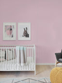 Wandpaneel in der Farbe Rosa, hinter weißem Babybett im Kinderzimmer