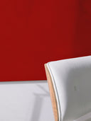 Wandpaneel in der Farbe Rot, installiert an der Wand vor einem Sessel