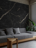 Wandpaneel in Marmoroptik, Black Marquina Gold, installiert an Wand im Wohnzimmer