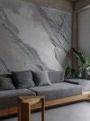 Wandpaneel in Marmoroptik, Portinari Grau, installiert an Wand im Wohnzimmer