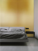 Wandpaneel in Metalloptik, Gold, installiert an der Schlafzimmer Wand hinter einem Bett