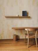 Softstone Wandpaneel, Beige, installiert an der Wand, mit Regalen an der Oberfläche, davor ein Stuhl