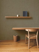 Softstone Wandpaneel, Braun, installiert an der Wand, mit Regalen an der Oberfläche, davor ein Stuhl