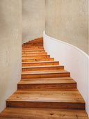 Softstone Wandpaneel, Creme, installiert an der Wand einer geschwungenen Treppe