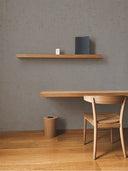 Softstone Wandpaneel, Grau, installiert an der Wand, mit Regalen an der Oberfläche, davor ein Stuhl