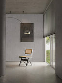 Softstone Wandpaneel lichtgrau an Wand, mit Bild, davor Stuhl und Stehlampe