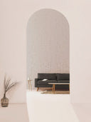 Softstone Wandpaneel, Lichtgrau, sichtbar durch einen Eingangs­bogen, im Wohnraum mit Sofa