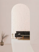 Softstone Wandpaneel, Off-White, sichtbar durch einen Eingangs­bogen, im Wohnraum mit Sofa