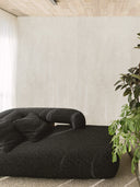 Wandpaneel in Steinoptik, Beton Creme, montiert hinter schwarzem Sofa, Wohnzimmer