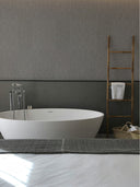 Hotelzimmer mit Bett und weißer Badewanne, Wandpaneel in Stoffoptik Leinen Grau an der Wand