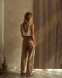 Blonde Frau steht vor Wandpaneel in Holzoptik in minimalistischem Raum